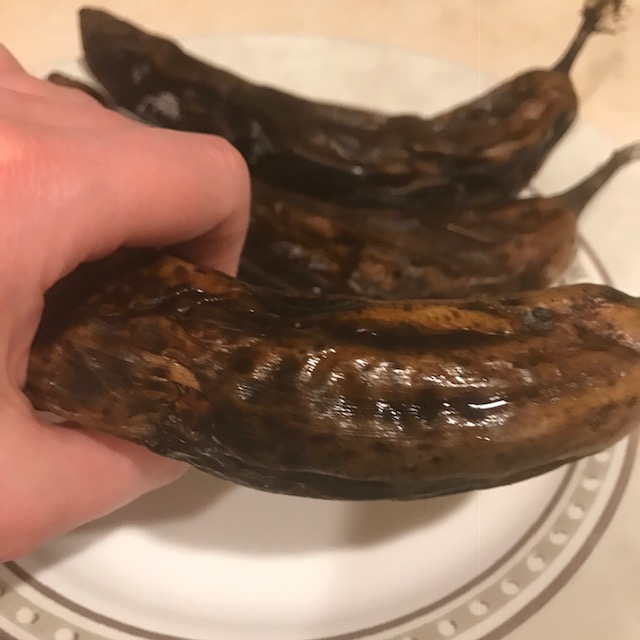 Creepy hand gripping a thawing black banana